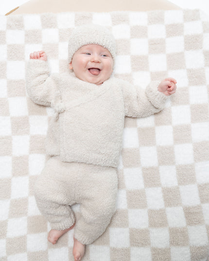 Baby wearing outfit with a kimono wrap top, pants, and hat 