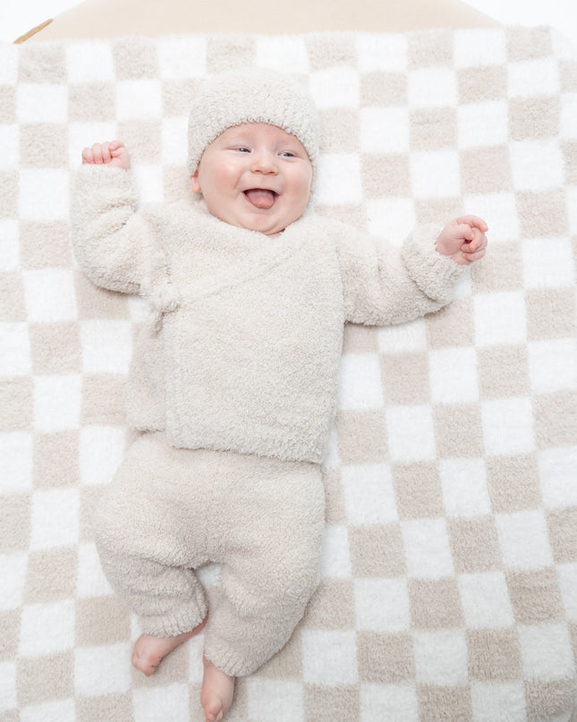 Baby wearing outfit with a kimono wrap top, pants, and hat 