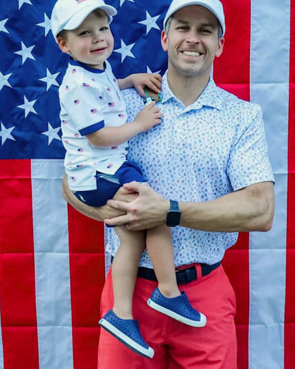 Man and child wearing matching American flag hats