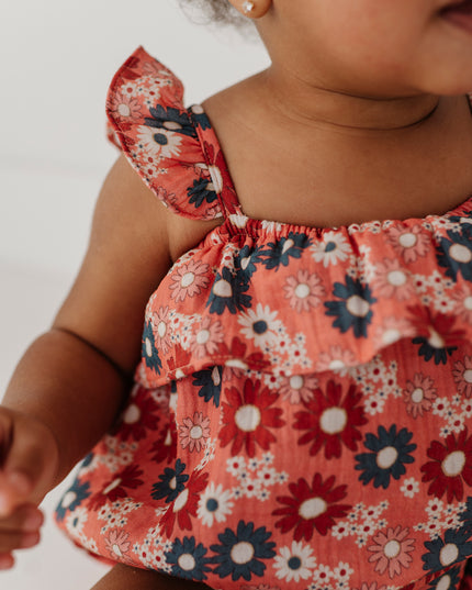 Baby wearing floral romper with ruffle sleeve