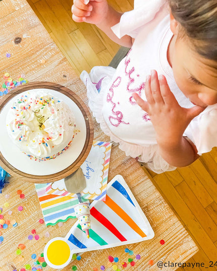 Child wearing 'Wish big' t-shirt eating cake