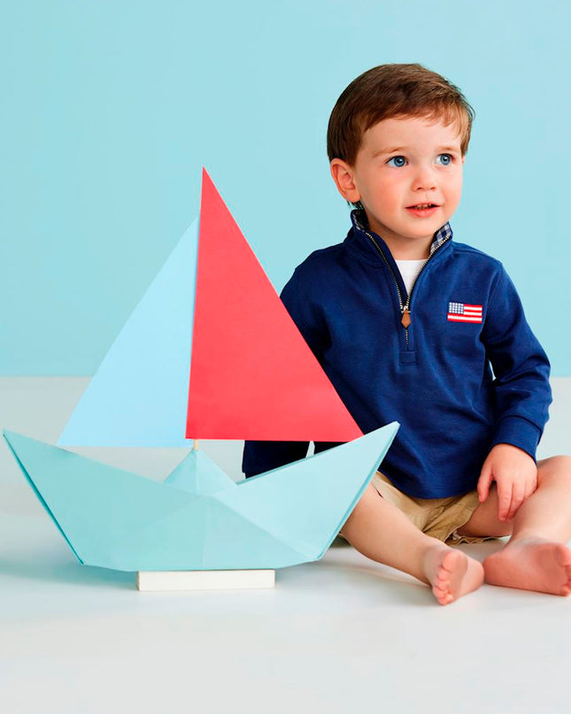Boy wearing navy blue quarter zip sweatshirt with American flag