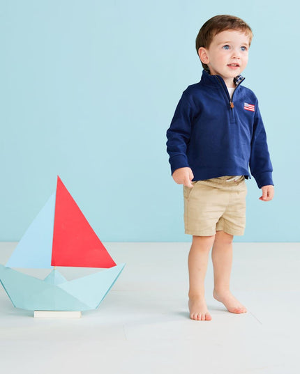 Boy wearing navy blue quarter zip sweatshirt with American flag