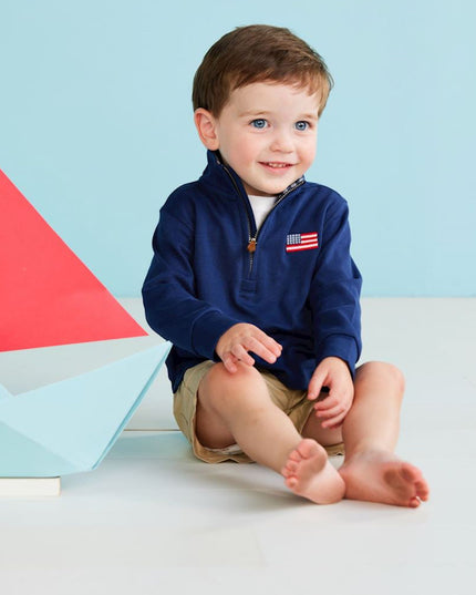 Boy wearing navy blue quarter zip sweatshirt with American flag