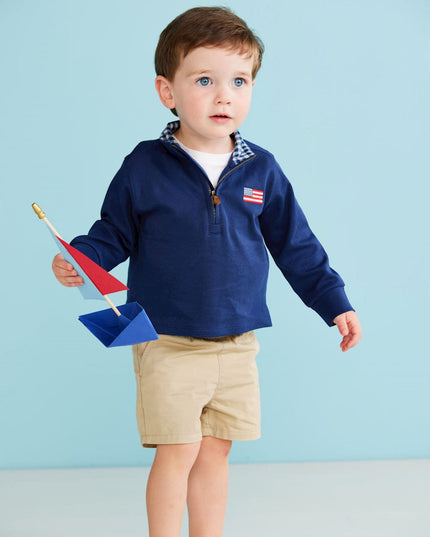 Boy wearing navy blue quarter zip sweatshirt with American flag