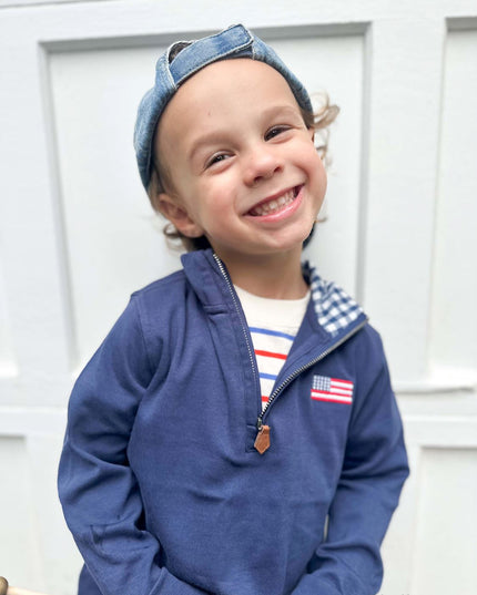 Boy wearing navy blue quarter zip sweatshirt with American flag