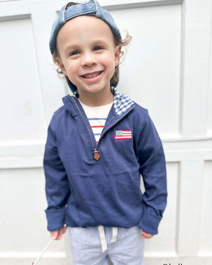 Boy wearing navy blue quarter zip sweatshirt with American flag