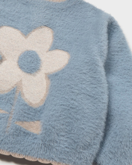 A light blue fuzzy long-sleeve sweater with a large cream-colored flower