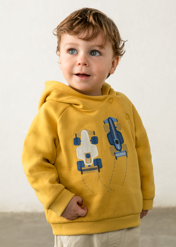Boy wearing Yellow hooded sweatshirt with white and blue race cars