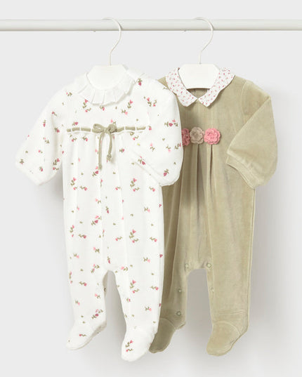 Two floral  baby rompers hanging on a white rack 