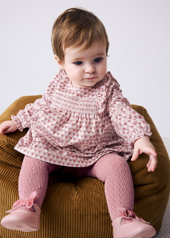 Baby wearing floral print dress and tights