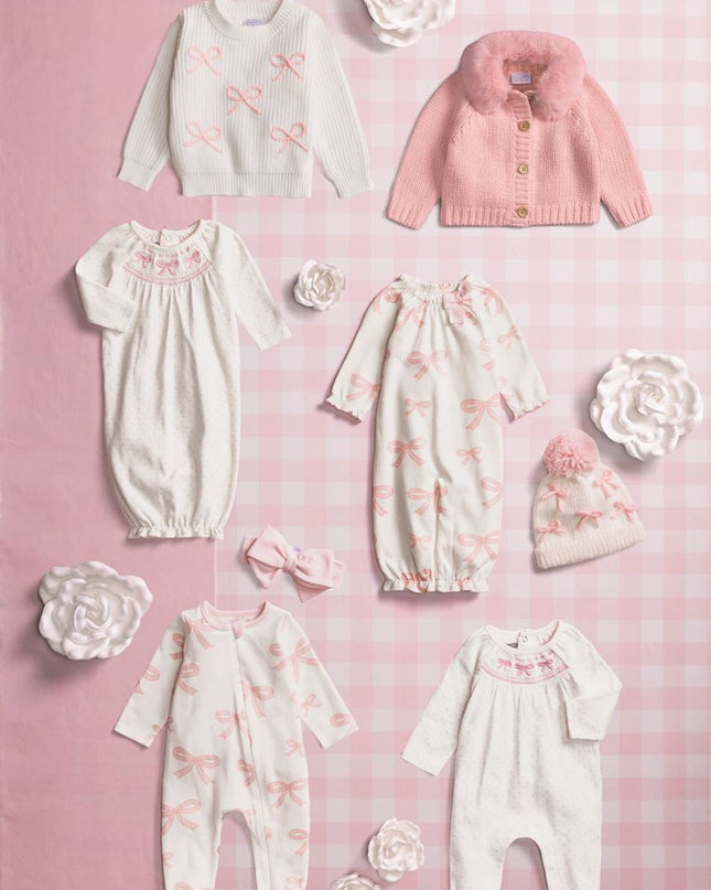 A flat lay of baby and kids pink and white bow themed clothing.