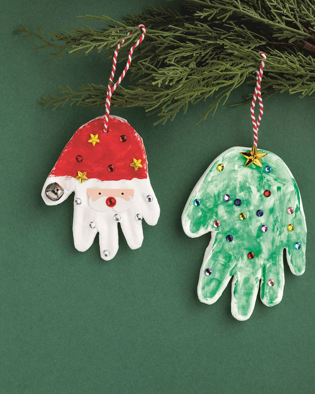 Hand-shaped Christmas ornaments on a green background with tree branches.