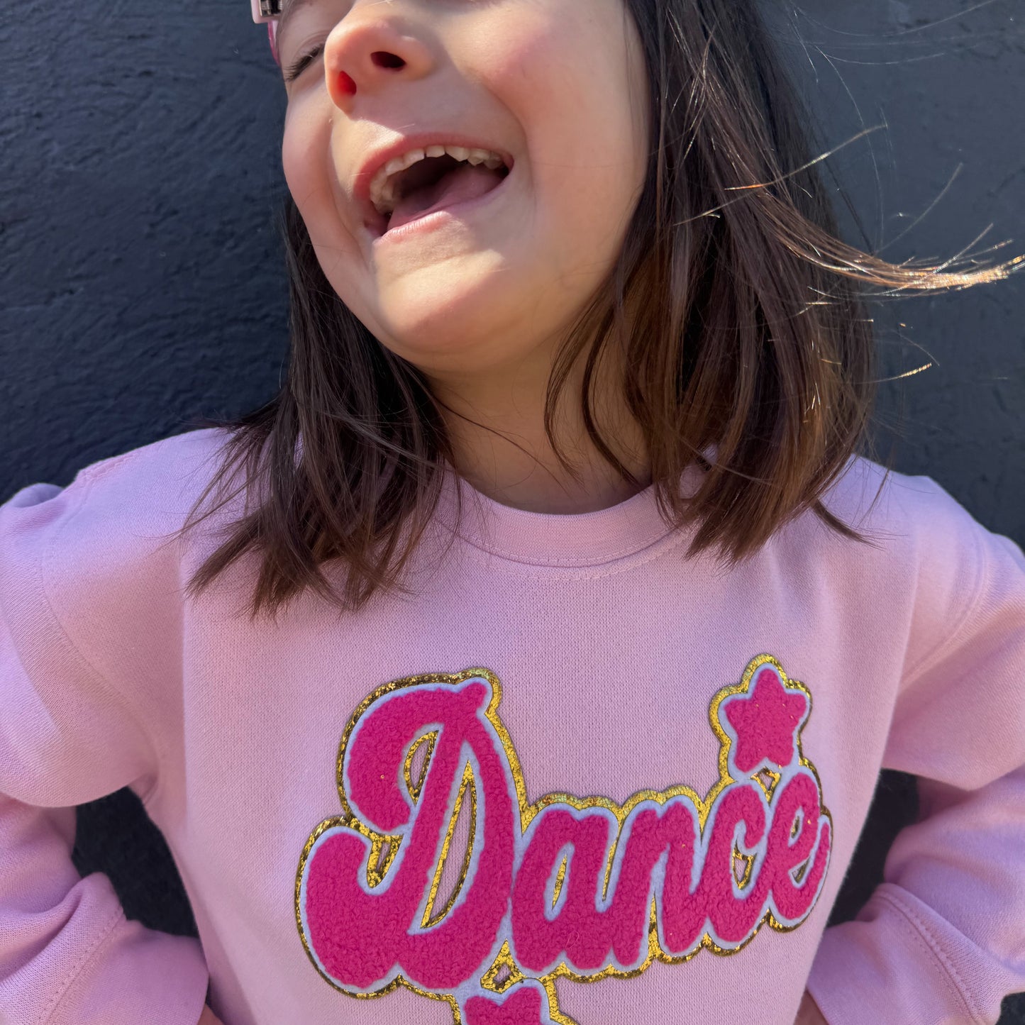 Girl wearing pink dance patch sweatshirt