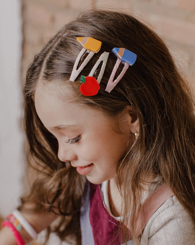 Girl wearing Set of three hair clips with an apple, blue pencil, and and yellow pencil design