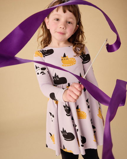 Girl wearing purple dress with black, white and gold cats wearing black witch hats
