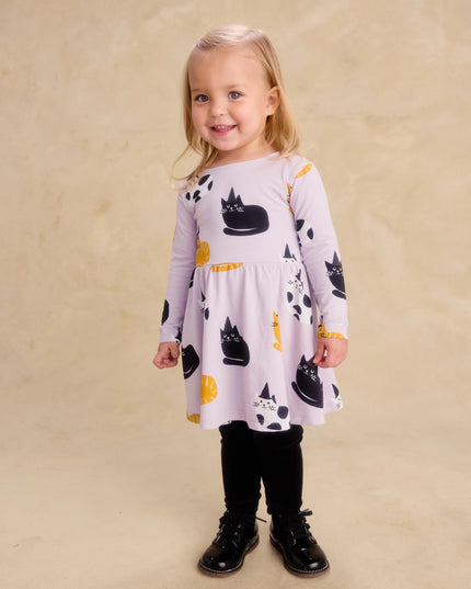 Girl wearing purple dress with black, white and gold cats wearing black witch hats