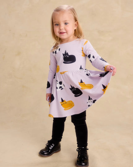 Girl wearing purple dress with black, white and gold cats wearing black witch hats