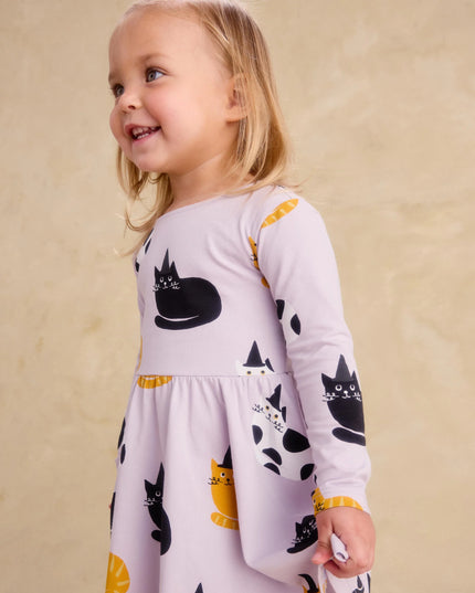 Girl wearing purple dress with black, white and gold cats wearing black witch hats