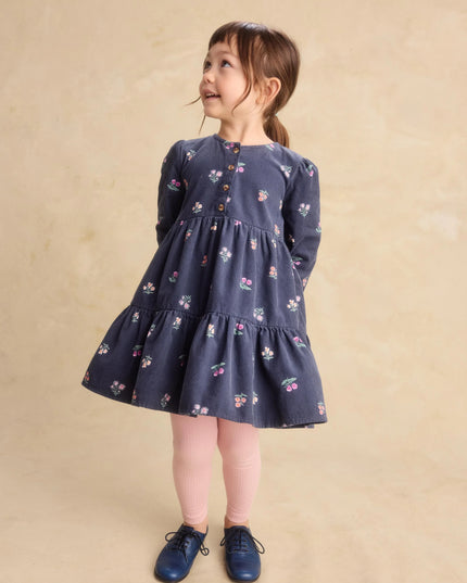 a young girl wearing a deep midnight corduroy shirtdress with floral pattern and pink leggings
