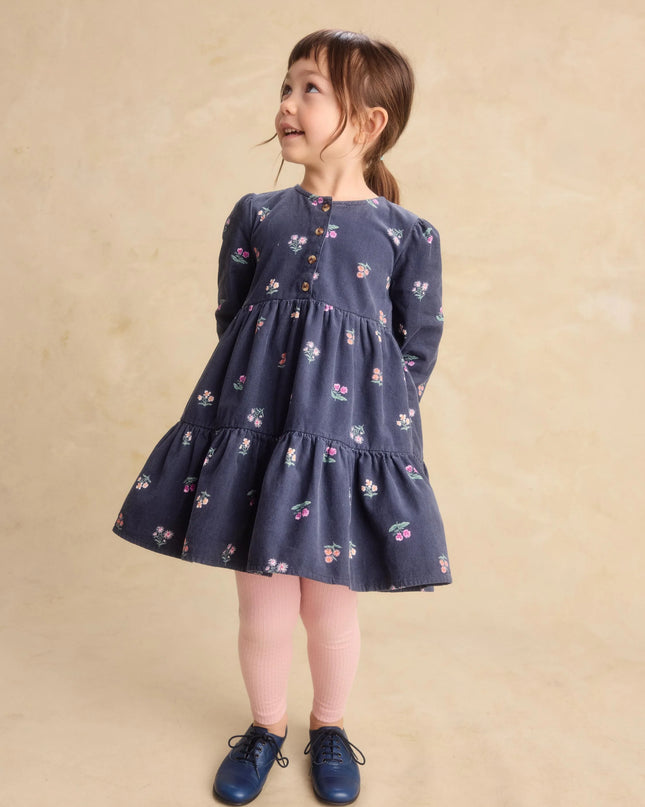 a young girl wearing a deep midnight corduroy shirtdress with floral pattern and pink leggings
