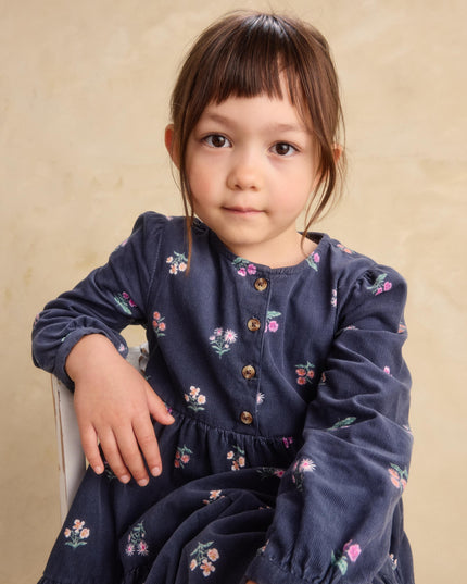 a young girl wearing a deep midnight corduroy shirtdress with floral pattern 