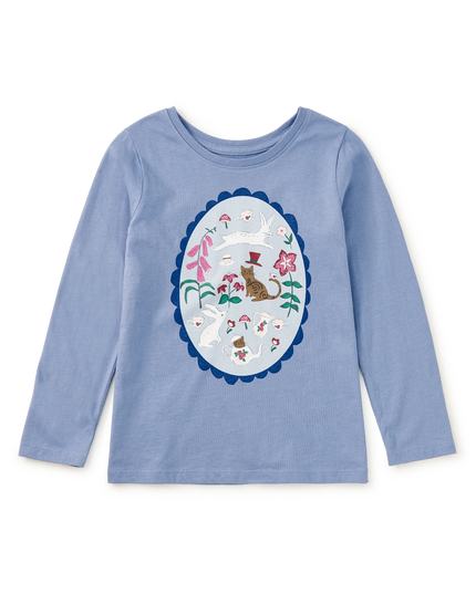 A light blue long-sleeve crewneck shirt for kids, featuring a large oval graphic print on the front with a whimsical cat and tea party design