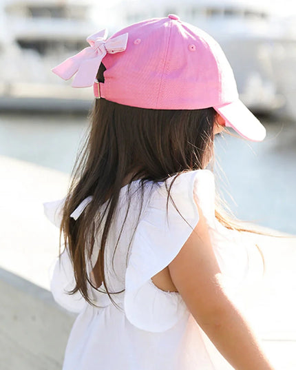 Girl wearing Pink baseball cap with a gold crown 