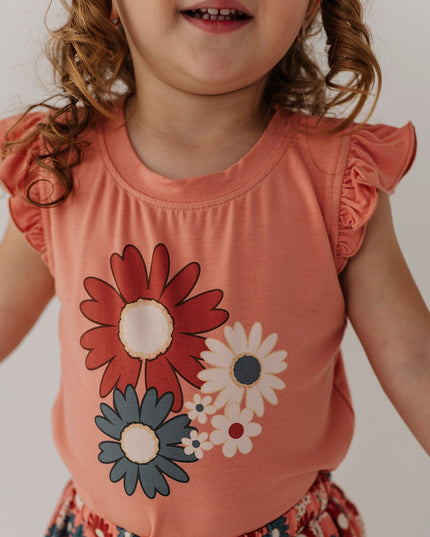 Girl wearing coral sleeveless top with floral design and matching skirt