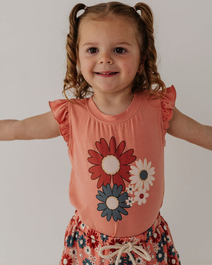 Girl wearing coral sleeveless top with floral design and matching skirt