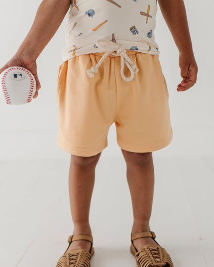 Boy wearing baseball print short and yellow shorts