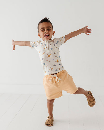 Boy wearing baseball print short and yellow shorts
