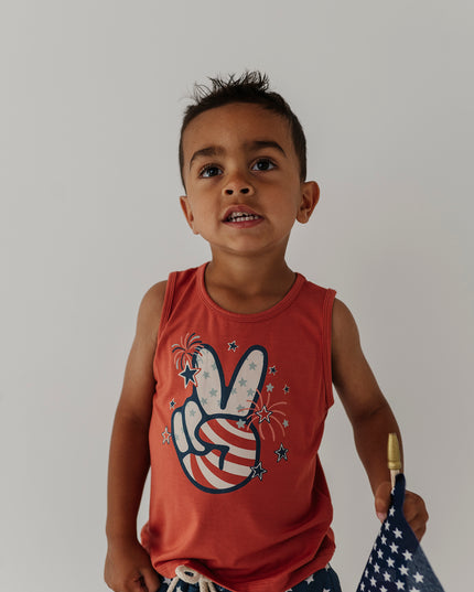 Child wearing red tank top with a peace sign and fireworks design 