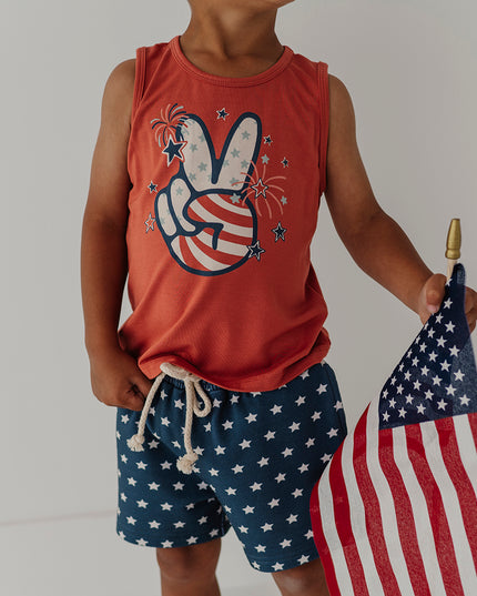 Child wearing red tank top with a peace sign and fireworks design 
