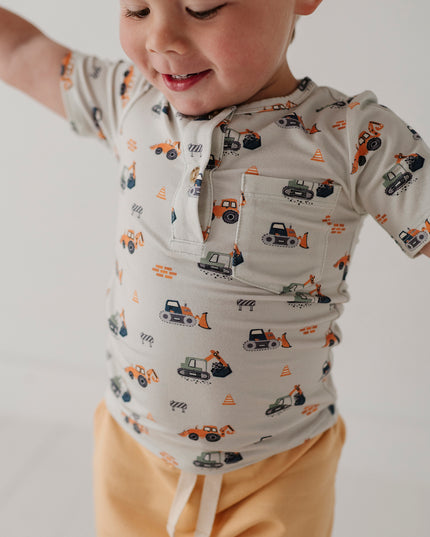 Child wearing henley shirt with construction truck print