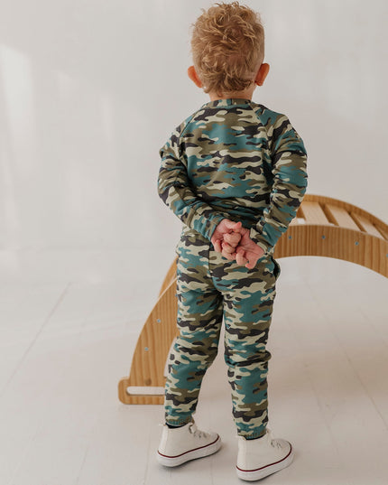 A child wearing a matching camouflage sweatshirt and jogger pants set