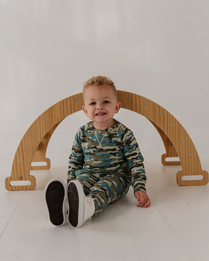 A child wearing a matching camouflage sweatshirt and jogger pants set