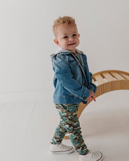 A child wearing a denim jacket and camouflage jogger pants