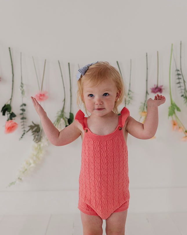Baby in a red knit bodysuit 