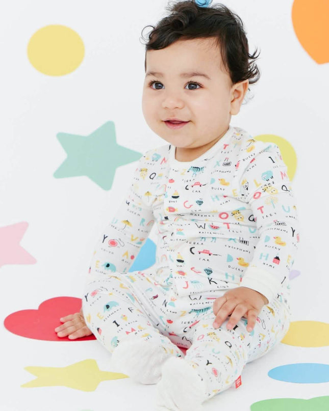 Baby wearing magnetic footie pajamas in ABC's print