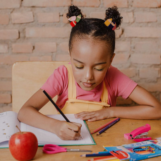 Girl wearing pencil hair ties writing in a notebook