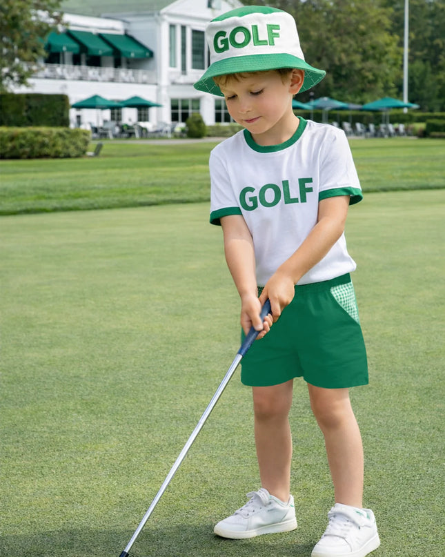 Boy wearing green and white golf outfit hitting a golf ball