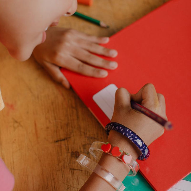 Girl coloring wearing "Be Kind" Apple Bangles 