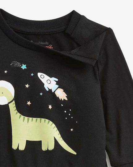 Close-up of a black long-sleeve top featuring a printed dinosaur and rocket graphic on the front with magnets at the neckline for easy dressing
