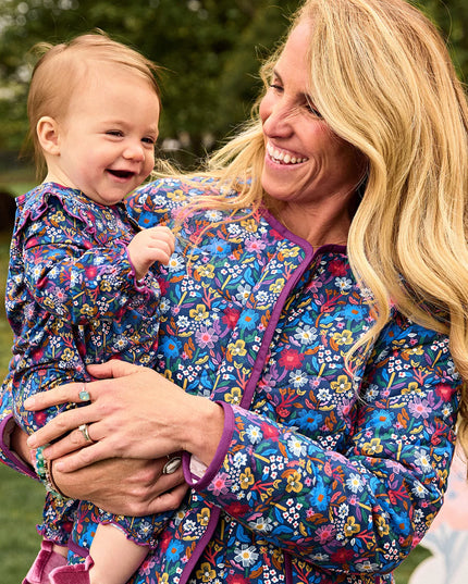 A woman and a baby wearing matching floral print outfits