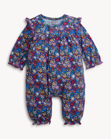 A baby girl's long-sleeve floral jumpsuit in a vibrant blue, purple, and pink mix, featuring ruffled shoulder details and gathered leg cuffs
