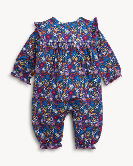 A baby girl's long-sleeve floral jumpsuit in a vibrant blue, purple, and pink mix, featuring ruffled shoulder details and gathered leg cuffs