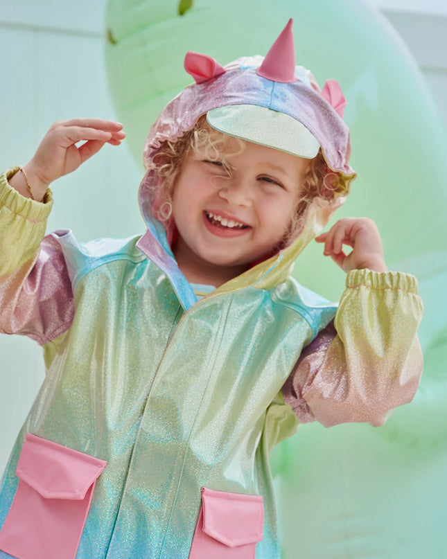 Girl wearing rainbow unicorn sparkle raincoat with magnetic closures