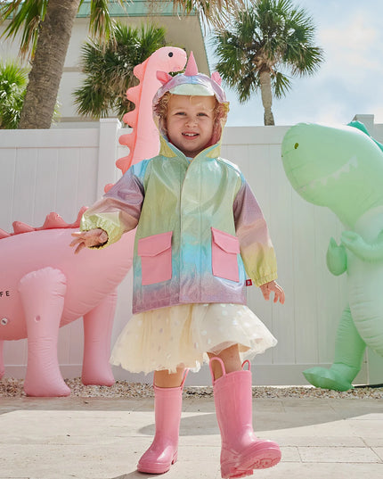 Girl wearing rainbow unicorn sparkle raincoat with magnetic closures