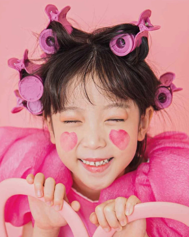 Girl with pink curlers in her hair and pink heart cheek stamps